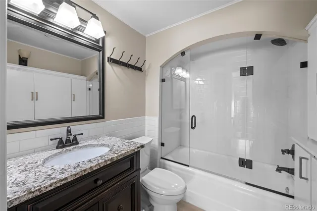 a bathroom with a granite countertop sink a toilet and shower