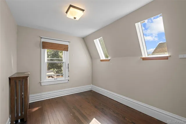 an empty room with a window and wooden floor