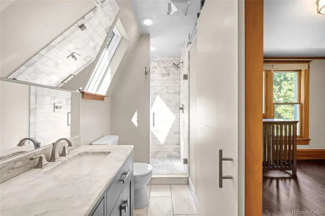 a bathroom with a granite countertop sink a mirror and a shower