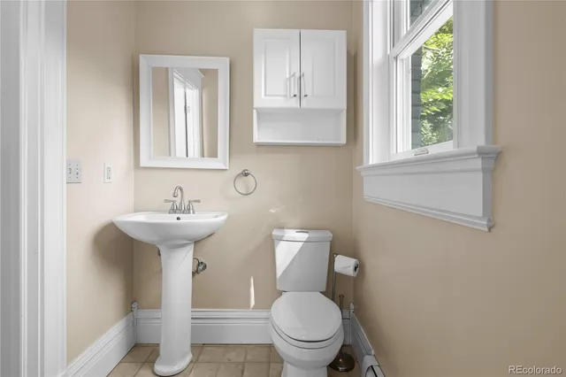 a bathroom with a sink toilet and a window