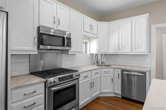 a kitchen with cabinets stainless steel appliances and sink