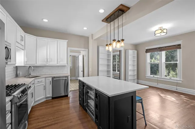 a kitchen with a stove a sink dishwasher a kitchen island with wooden cabinets and floor