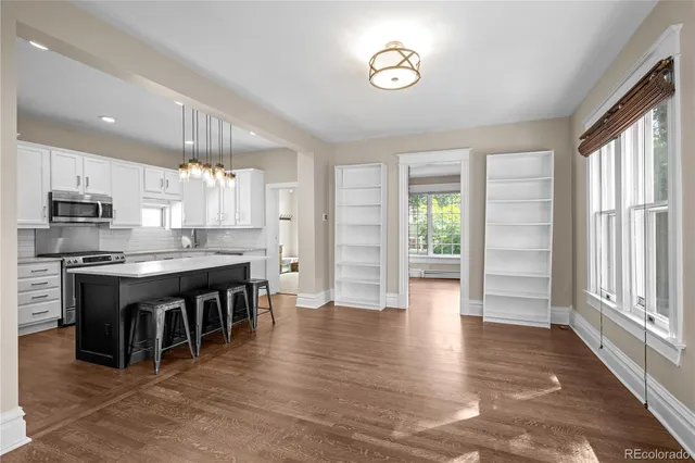 an open kitchen with granite countertop a stove top oven a sink and a refrigerator