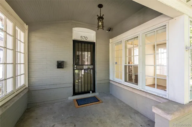 a view of a house with a small yard plants and large tree