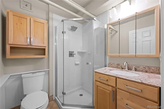 a bathroom with a granite countertop sink toilet and shower