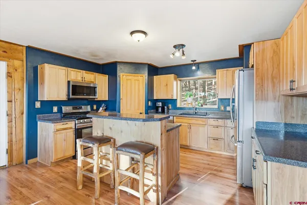 a kitchen with a table chairs refrigerator and cabinets