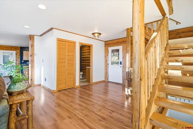 a view of a room with wooden floor staircase and a kitchen