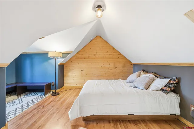 a view of a bedroom with wooden floor and a window
