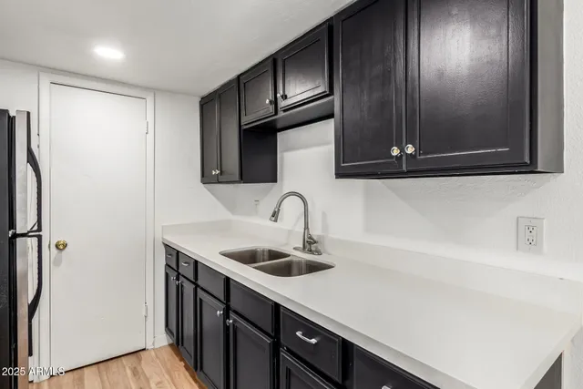 a kitchen with stainless steel appliances a sink dishwasher a refrigerator and cabinets