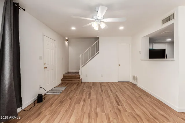 a view of a room with wooden floor and white walls