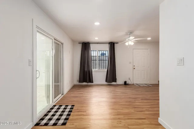 a view of a hallway with wooden floor and a window