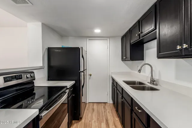 a kitchen with stainless steel appliances a sink stove and refrigerator