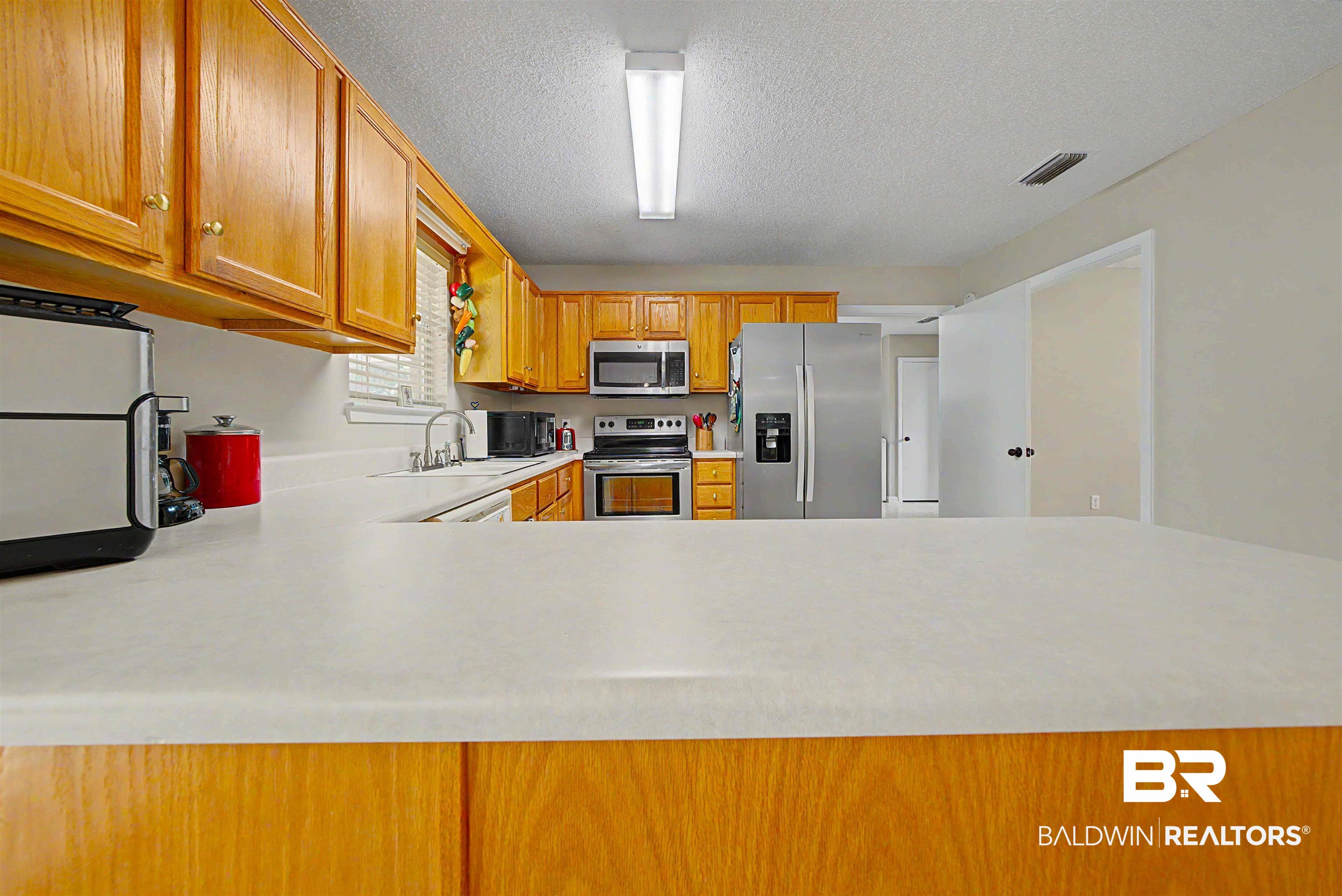 22963 Highway 98 Foley, AL 36535 - Photo 11 of 52 Kitchen featuring wood cabinetry, white countertops, a stainless steel side-by-side refrigerator, a stainless steel range, and a stainless steel microwave