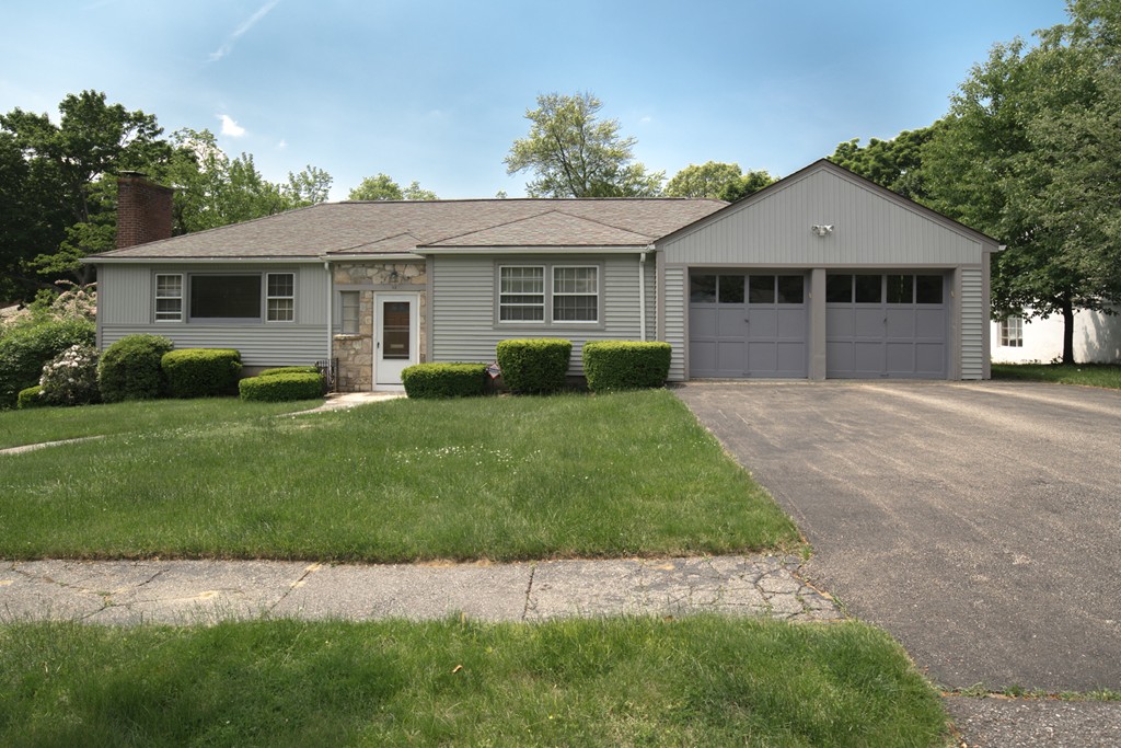 a front view of a house with a garden and yard