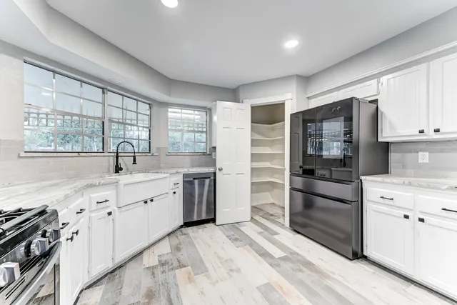 a kitchen with granite countertop a refrigerator stove top oven and sink