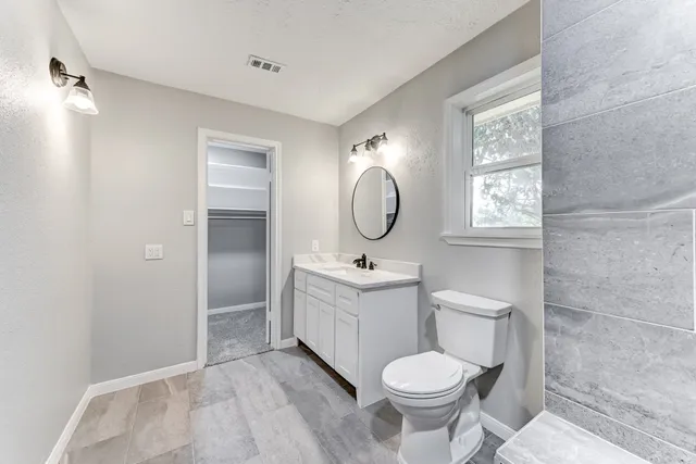 a bathroom with a toilet sink and mirror