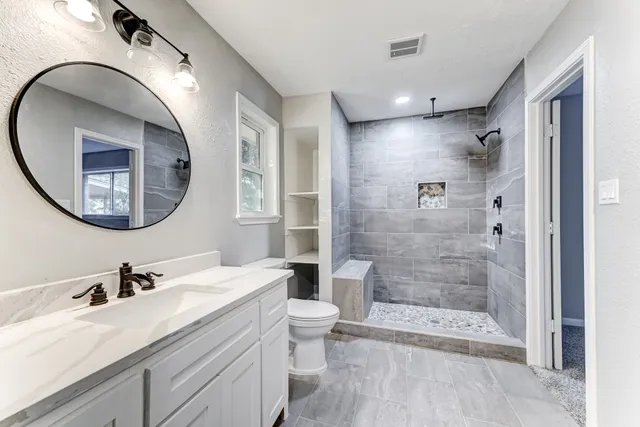 a bathroom with a double vanity sink mirror and shower