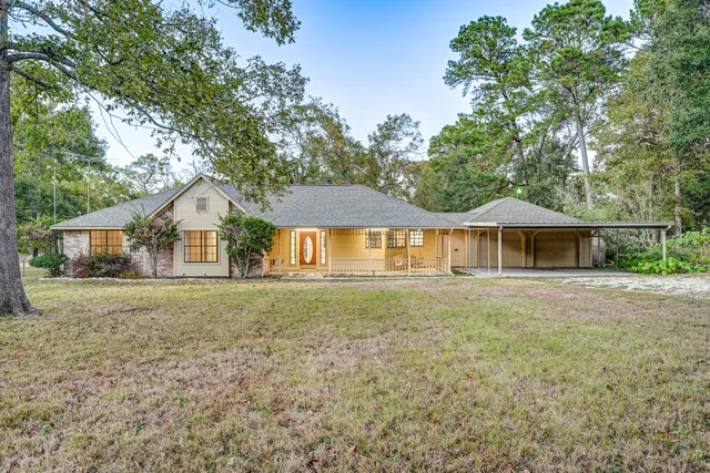 a front view of a house with a yard and trees