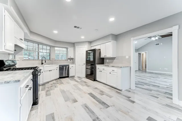 a kitchen with white cabinets and stainless steel appliances
