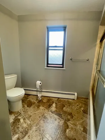 a bathroom with a toilet and a window