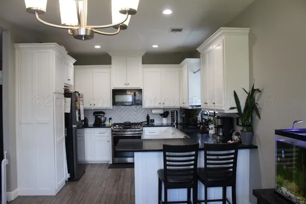 a kitchen with kitchen island granite countertop a sink cabinets and stainless steel appliances