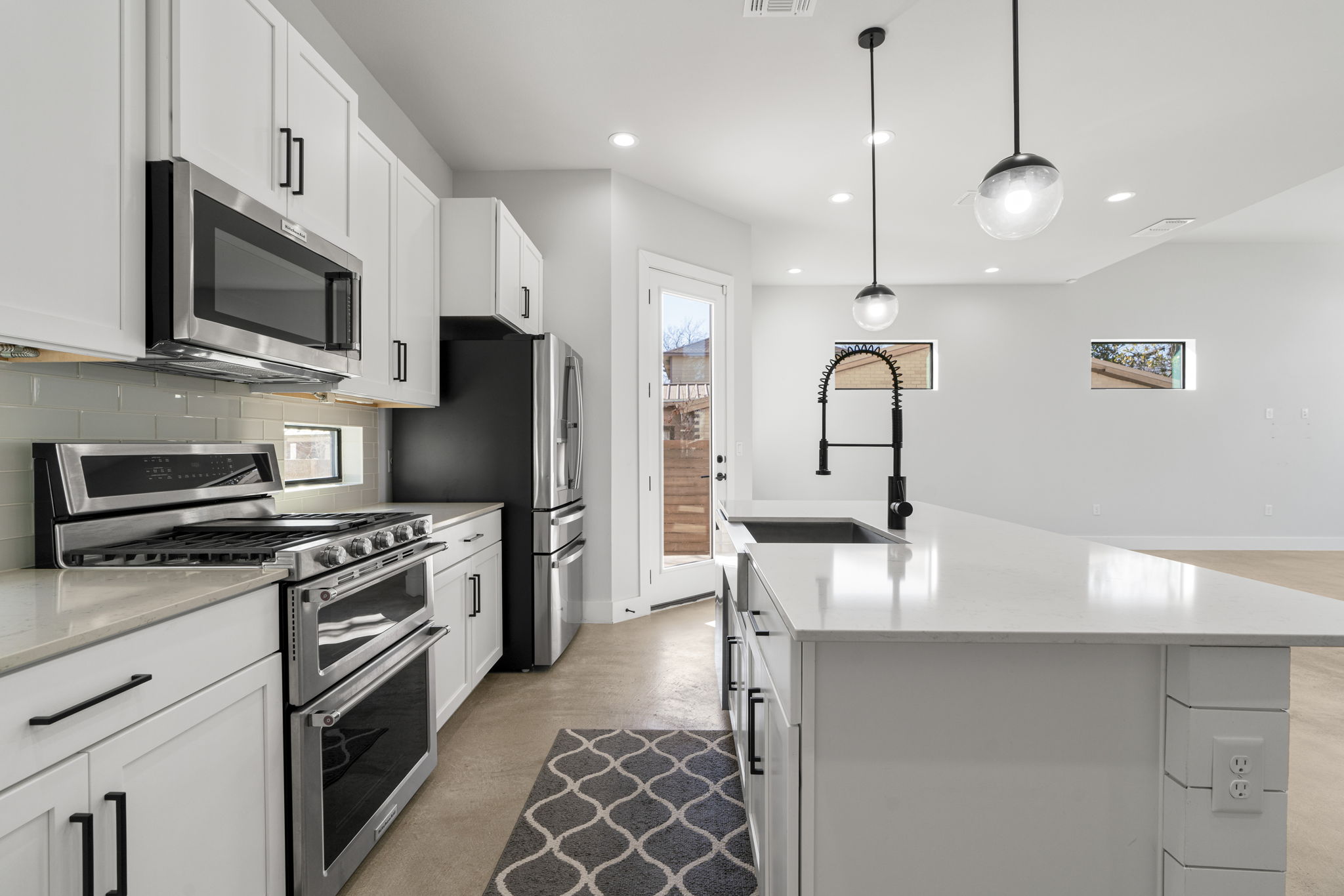 1405 Perez Street, Unit 1 Austin, TX 78721 - Photo 11 of 31 a kitchen with stainless steel appliances granite countertop a stove top oven a sink dishwasher a refrigerator and a microwave