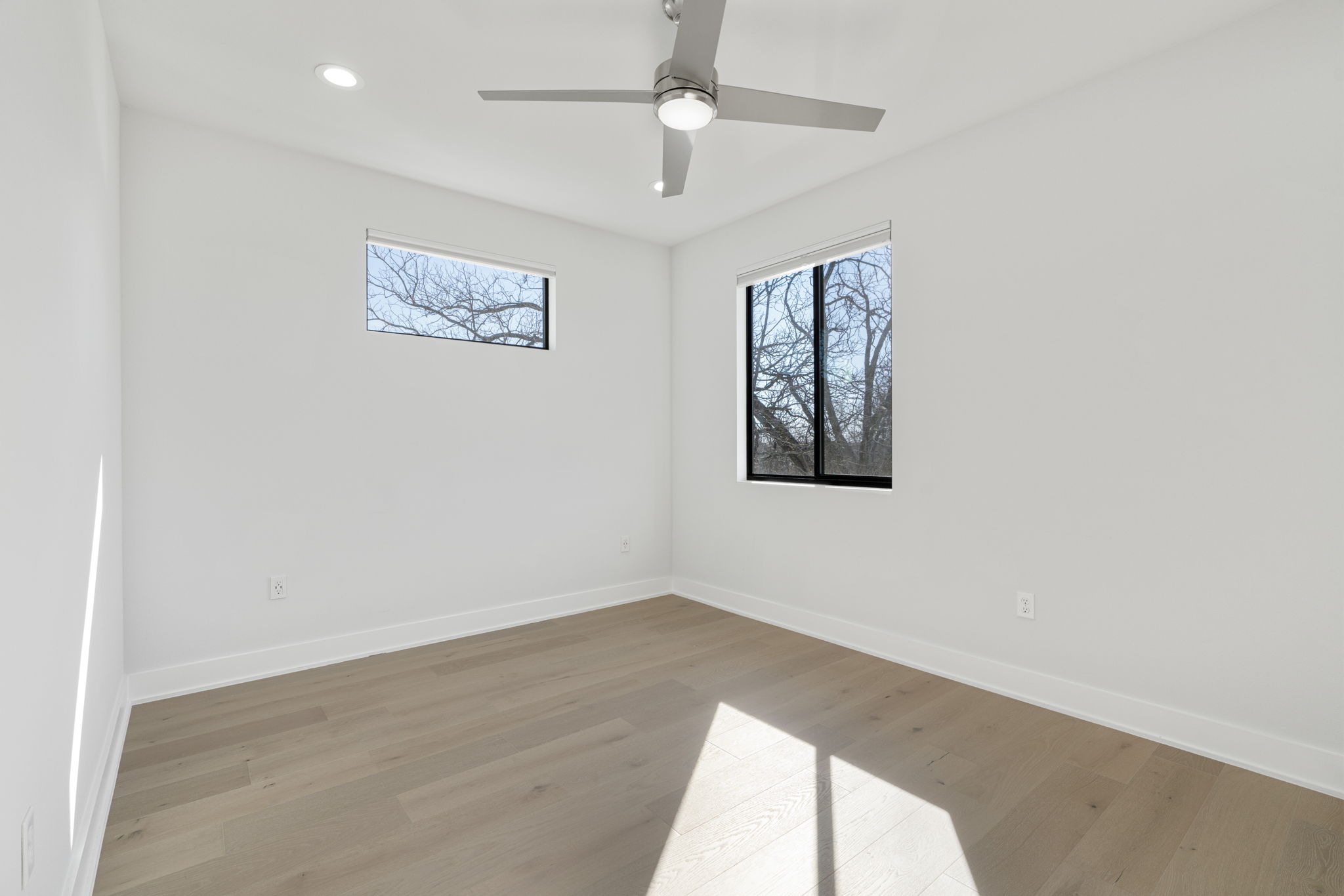 1405 Perez Street, Unit 1 Austin, TX 78721 - Photo 19 of 31 an empty room with wooden floor ceiling fan and windows