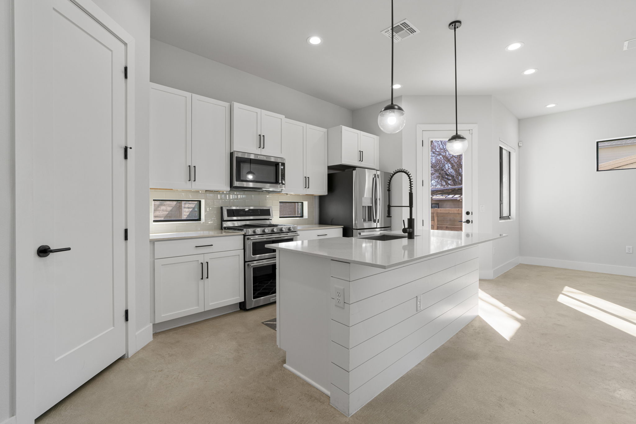 1405 Perez Street, Unit 1 Austin, TX 78721 - Photo 10 of 31 a kitchen with kitchen island white cabinets and stainless steel appliances