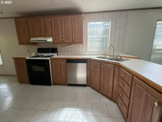 a kitchen with a sink a stove cabinets and a microwave