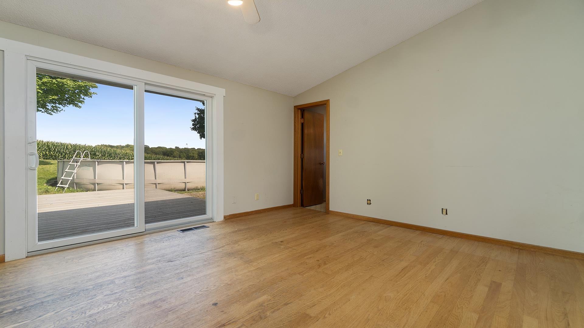 9807 North Leaf River Road Leaf River, IL 61047 - Photo 11 of 37 a view of an empty room with wooden floor and a window