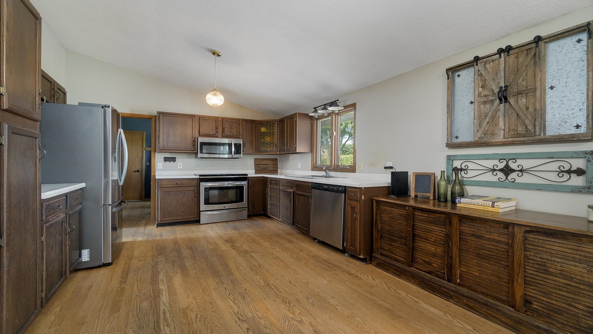 9807 North Leaf River Road Leaf River, IL 61047 - Photo 5 of 37 a kitchen with stainless steel appliances granite countertop a refrigerator a sink dishwasher a stove with wooden cabinets and floor