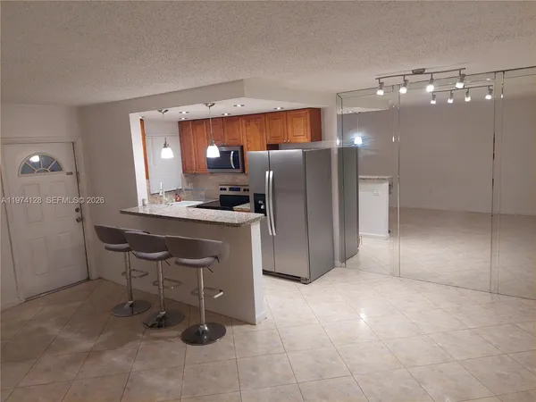 a kitchen with a refrigerator a sink and chairs