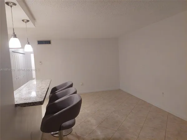 a view of a hallway with a furniture and a refrigerator