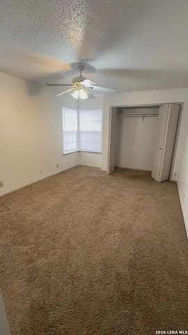 an empty room with windows and ceiling fan view