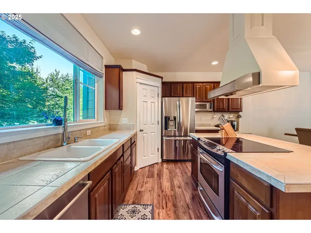 a kitchen with granite countertop a sink a counter space appliances and cabinets