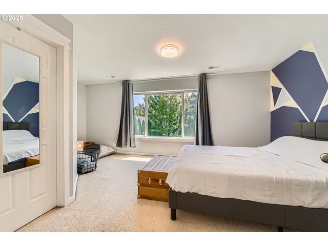 a bedroom with a bed and large windows