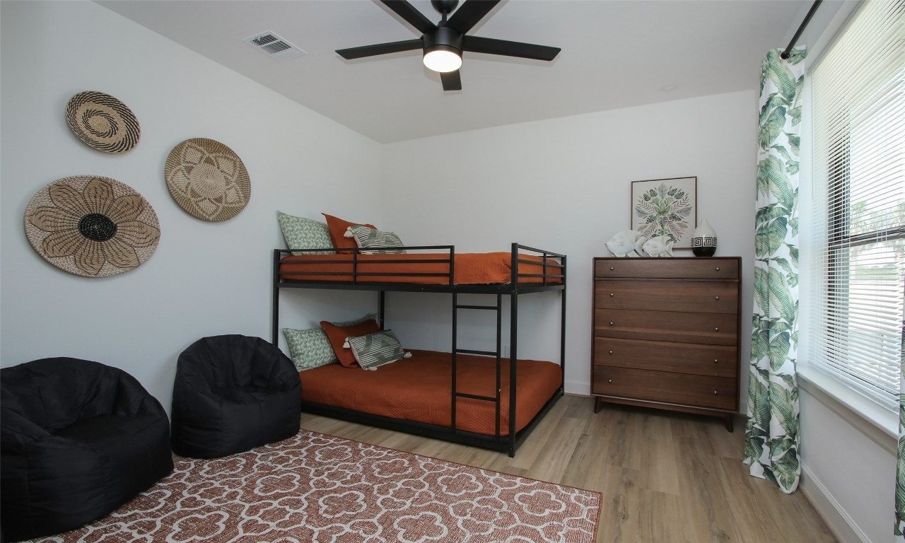 1817 Todville Road Seabrook, TX 77586 - Photo 18 of 27 a bedroom with a bed a clock on dresser and a window