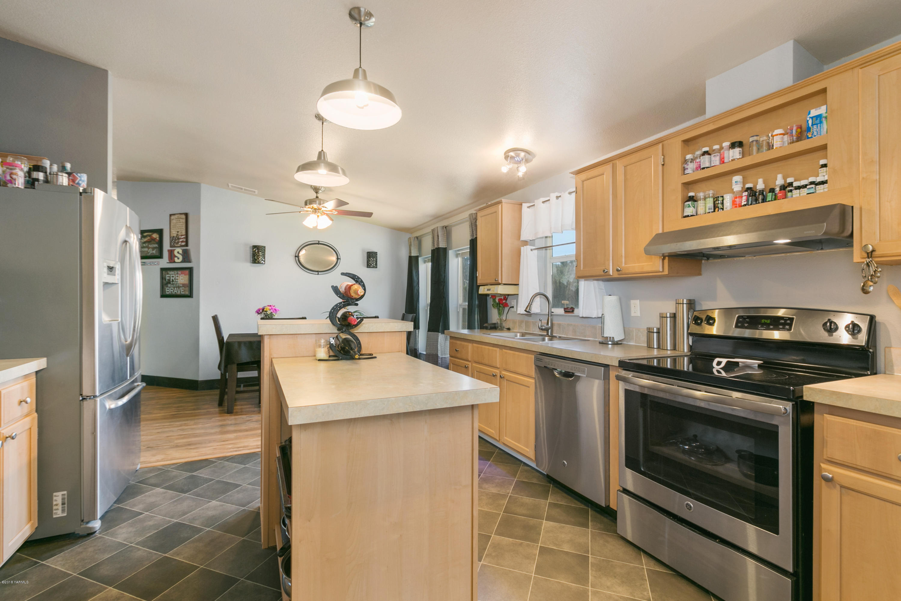 22490 Ahtanum Road Yakima, WA 98903 - Photo 6 of 20 a kitchen with stainless steel appliances granite countertop a sink a stove a refrigerator and a dining table with wooden floor