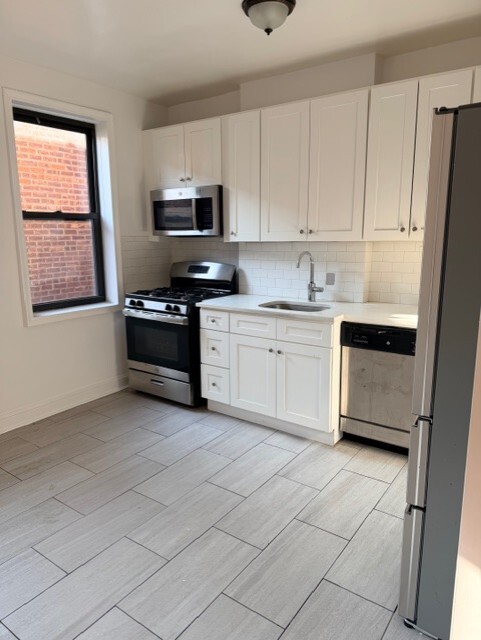 a kitchen with stainless steel appliances granite countertop a stove a sink and a refrigerator