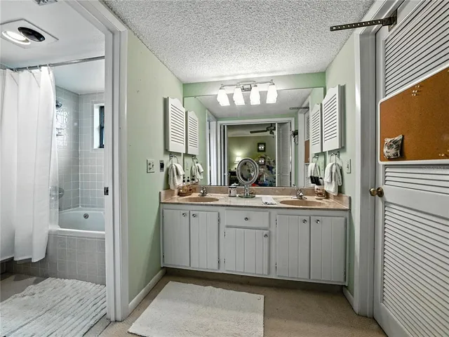 a spacious bathroom with a double vanity sink a large mirror and a shower