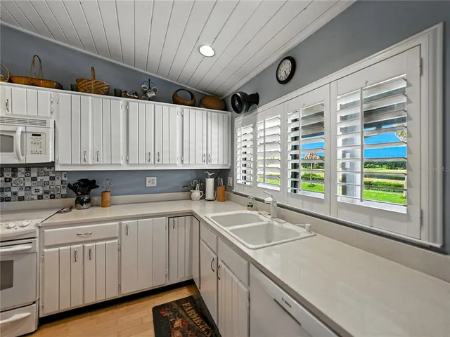 a kitchen with a sink window and cabinets