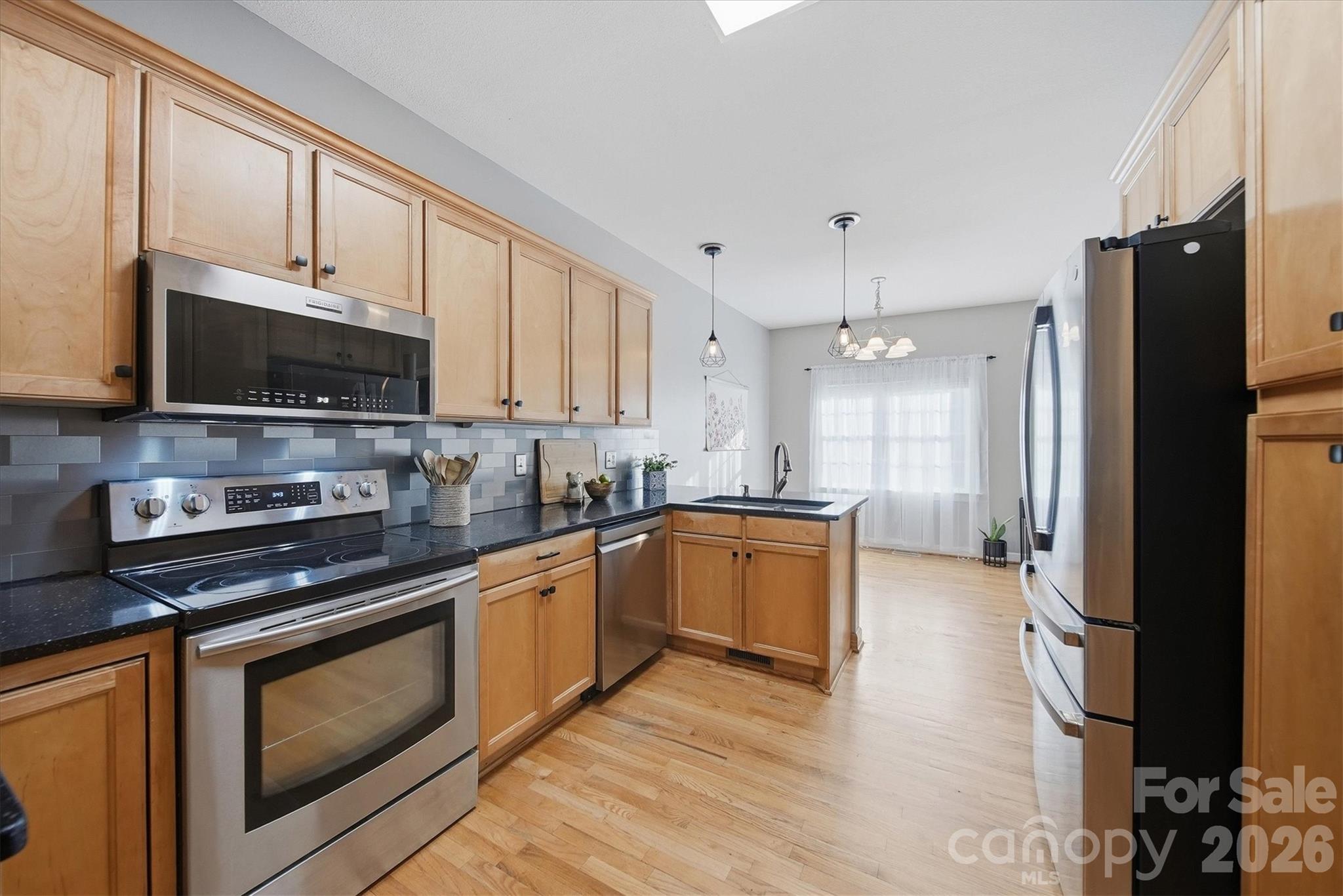 2555 Knox Landing Road Connelly Springs, NC 28612 - Photo 12 of 48 a large kitchen with stainless steel appliances granite countertop a stove a sink and a refrigerator