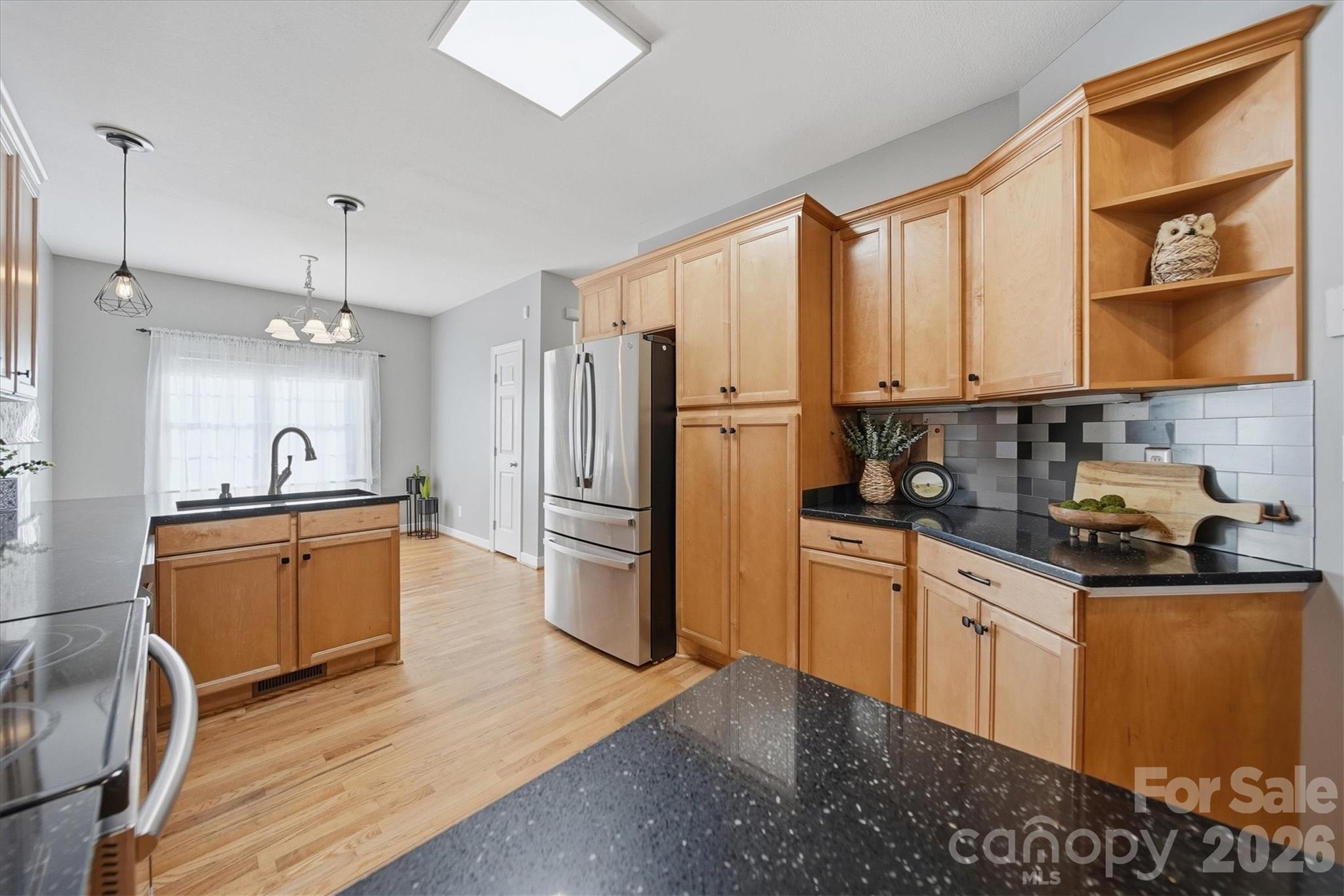 2555 Knox Landing Road Connelly Springs, NC 28612 - Photo 13 of 48 a kitchen with stainless steel appliances granite countertop a refrigerator a sink dishwasher a stove with wooden cabinets and floor