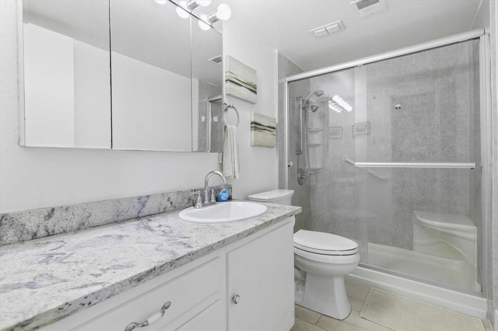 4100 Ridglea Country Club Drive, Unit 1403 Fort Worth, TX 76126 - Photo 11 of 17 a bathroom with a granite countertop sink toilet and shower