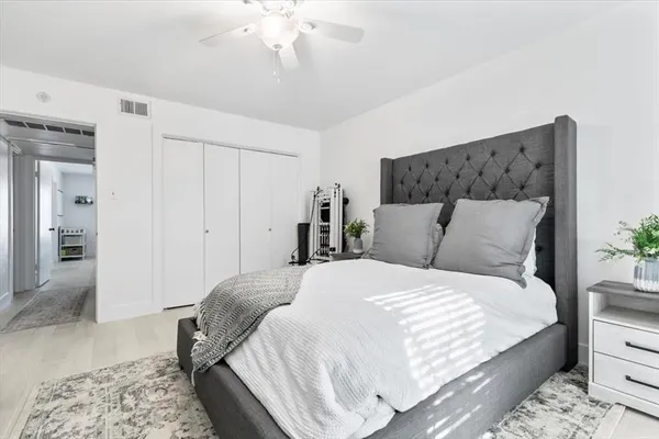 a bedroom with a large bed and a chandelier