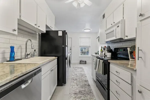 a kitchen with stainless steel appliances granite countertop a refrigerator a stove and a sink with cabinets