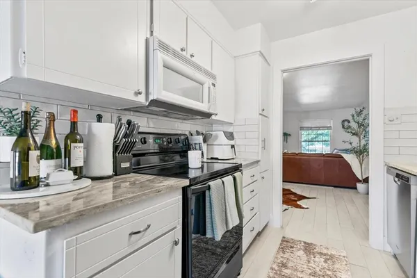 a kitchen with stainless steel appliances granite countertop a sink and a stove