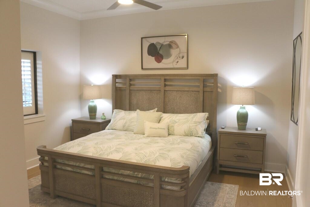 18269 Colony Drive, Unit 803 Fairhope, AL 36532 - Photo 15 of 27 Bedroom featuring ornamental molding, a ceiling fan, and wood finished floors