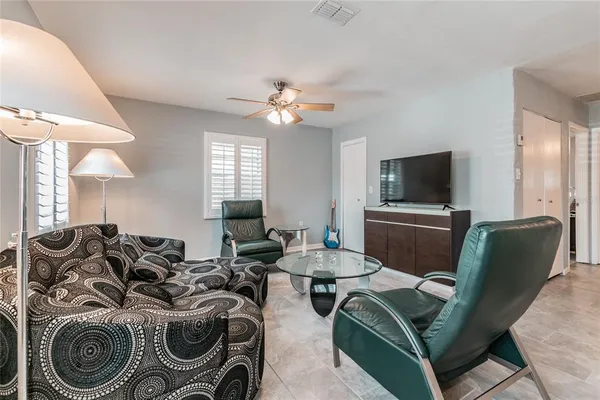 a living room with furniture a chandelier and a flat screen tv