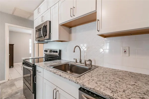 a kitchen with stainless steel appliances granite countertop a sink and a stove